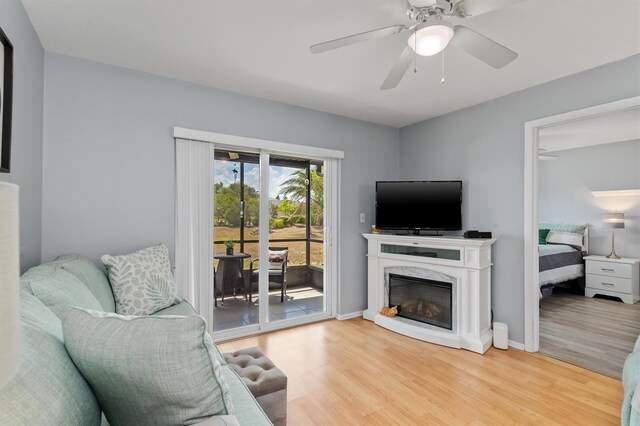 25275 Rampart Blvd Unit 1504, Punta Gorda, FL 33983 - living area with wood finished floors, a ceiling fan, baseboards, and a premium fireplace