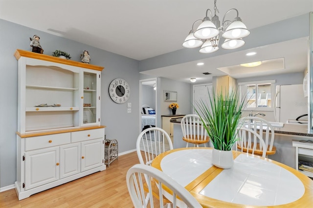 25275 Rampart Blvd Unit 1504, Punta Gorda, FL 33983 - dining area with light wood-style flooring, a chandelier, and baseboards