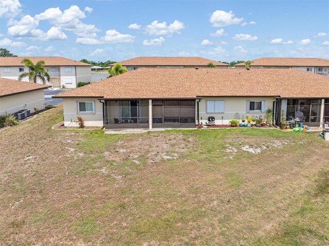 25275 Rampart Blvd Unit 1504, Punta Gorda, FL 33983 - rear view of house with a sunroom, central AC unit, a lawn, and stucco siding