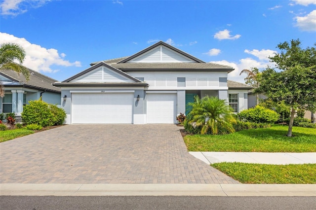 19821 Montenero Way, Venice, FL 34293 - view of front facade featuring decorative driveway, stucco siding, a garage, and a tiled roof