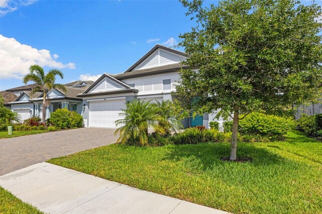 19821 Montenero Way, Venice, FL 34293 - view of front of home with a front lawn, decorative driveway, a garage, and stucco siding