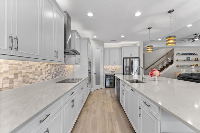 19821 Montenero Way, Venice, FL 34293 - kitchen with wall chimney exhaust hood, a sink, beverage cooler, stainless steel appliances, and decorative backsplash