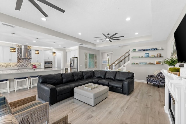 19821 Montenero Way, Venice, FL 34293 - living area featuring ceiling fan, a raised ceiling, recessed lighting, light wood finished floors, and stairs