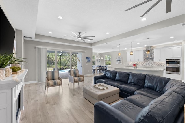 19821 Montenero Way, Venice, FL 34293 - living room featuring ceiling fan, light wood finished floors, baseboards, and recessed lighting