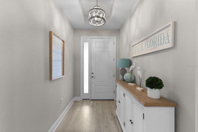 19821 Montenero Way, Venice, FL 34293 - foyer entrance with light wood-style flooring, baseboards, and a chandelier