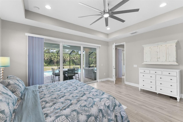 19821 Montenero Way, Venice, FL 34293 - bedroom with access to exterior, light wood-style flooring, baseboards, recessed lighting, and a tray ceiling