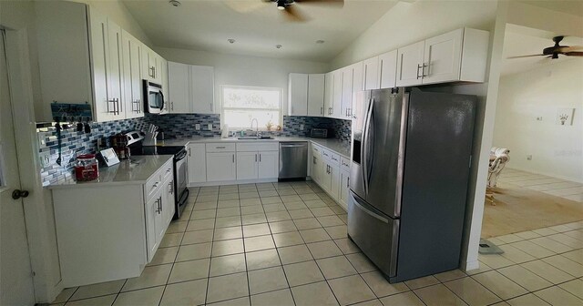 24239 Yacht Club Blvd, Punta Gorda, FL 33955 - kitchen with appliances with stainless steel finishes, ceiling fan, light tile patterned flooring, lofted ceiling, and decorative backsplash