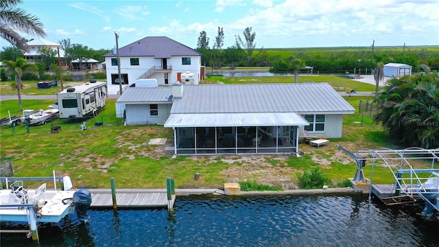 24239 Yacht Club Blvd, Punta Gorda, FL 33955 - rear view of property featuring a sunroom, a water view, a metal roof, and a yard
