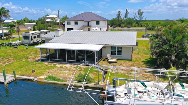 24239 Yacht Club Blvd, Punta Gorda, FL 33955 - rear view of property with a sunroom, a water view, a metal roof, and a lawn