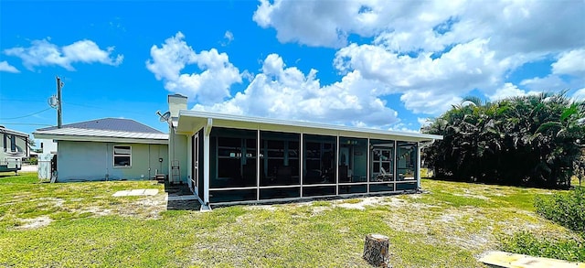 24239 Yacht Club Blvd, Punta Gorda, FL 33955 - rear view of property featuring a sunroom, a lawn, and a chimney