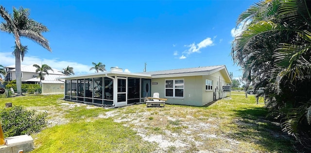 24239 Yacht Club Blvd, Punta Gorda, FL 33955 - back of house with a sunroom, a lawn, and a metal roof
