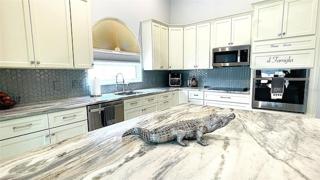 2399 Bendway Dr, Port Charlotte, FL 33948 - kitchen with appliances with stainless steel finishes, a sink, light stone countertops, tasteful backsplash, and white cabinetry