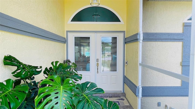 2399 Bendway Dr, Port Charlotte, FL 33948 - view of exterior entry featuring stucco siding and french doors