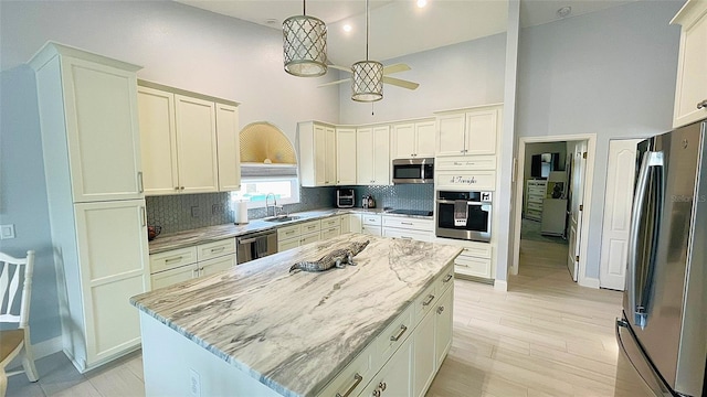 2399 Bendway Dr, Port Charlotte, FL 33948 - kitchen featuring appliances with stainless steel finishes, a towering ceiling, decorative backsplash, light stone counters, and baseboards