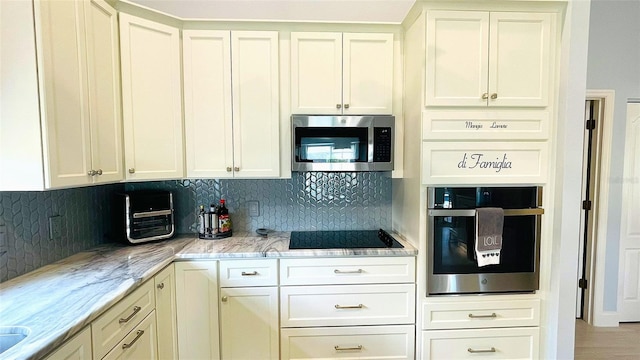 2399 Bendway Dr, Port Charlotte, FL 33948 - kitchen with appliances with stainless steel finishes, tasteful backsplash, light stone countertops, and white cabinetry