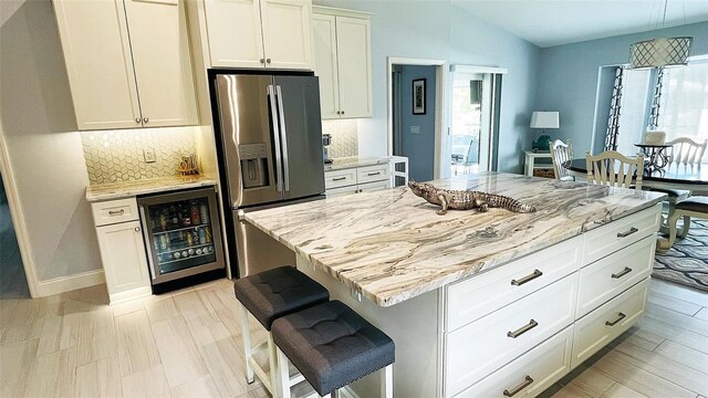 2399 Bendway Dr, Port Charlotte, FL 33948 - kitchen featuring beverage cooler, stainless steel fridge with ice dispenser, tasteful backsplash, light stone countertops, and lofted ceiling