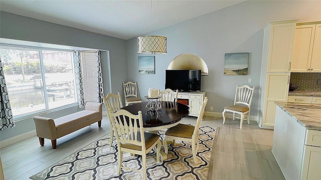 2399 Bendway Dr, Port Charlotte, FL 33948 - dining space with light wood-style flooring, baseboards, and lofted ceiling