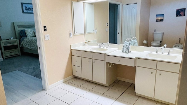 2399 Bendway Dr, Port Charlotte, FL 33948 - ensuite bathroom featuring double vanity, tile patterned floors, toilet, and baseboards