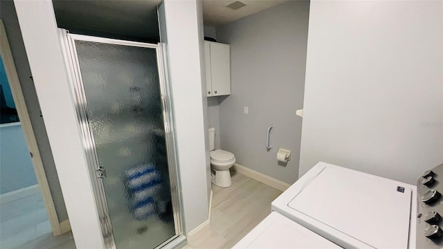 2399 Bendway Dr, Port Charlotte, FL 33948 - bathroom with a shower stall, toilet, baseboards, washer / dryer, and wood finished floors