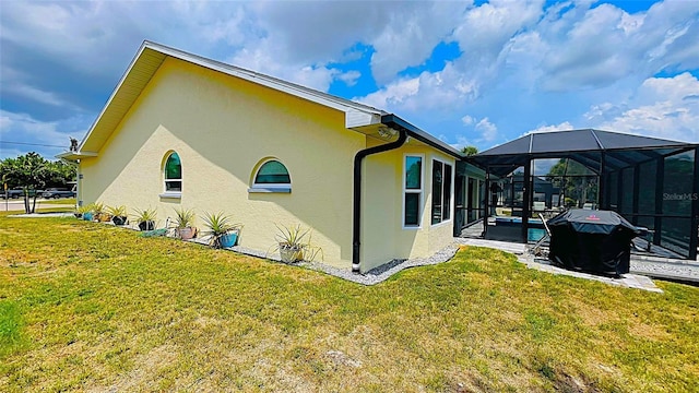 2399 Bendway Dr, Port Charlotte, FL 33948 - view of side of property featuring stucco siding, a lawn, a patio, and glass enclosure