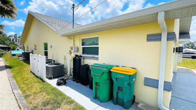 2399 Bendway Dr, Port Charlotte, FL 33948 - view of side of home with central air condition unit, stucco siding, and a shingled roof