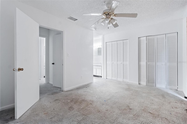 1515 Paul Russell Rd # 64, Tallahassee, FL 32301 - unfurnished bedroom featuring multiple closets, carpet floors, a textured ceiling, baseboards, and ceiling fan