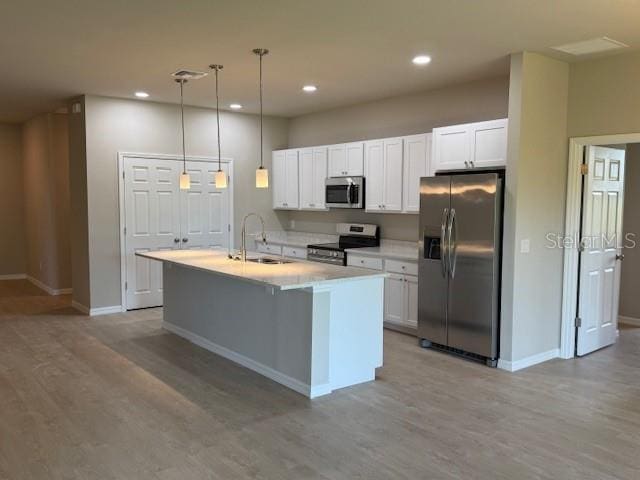 207 Baytree Dr, Rotonda West, FL 33947 - kitchen featuring appliances with stainless steel finishes, a sink, light wood-style flooring, white cabinets, and recessed lighting