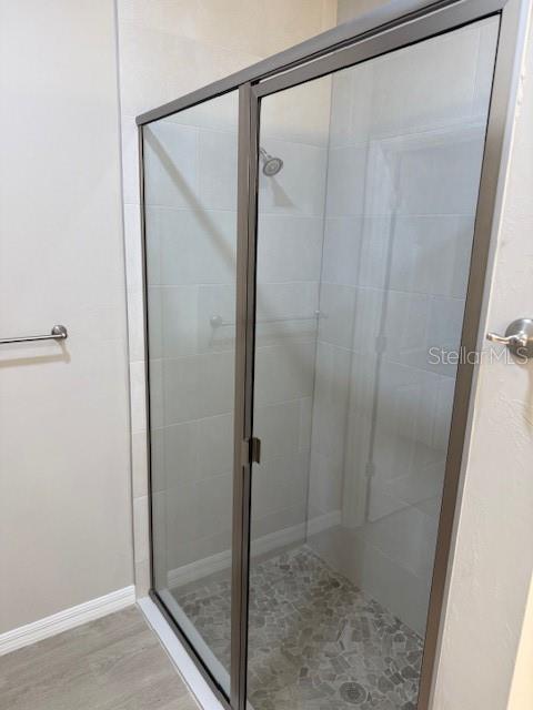 207 Baytree Dr, Rotonda West, FL 33947 - bathroom featuring a shower stall, wood finished floors, and baseboards