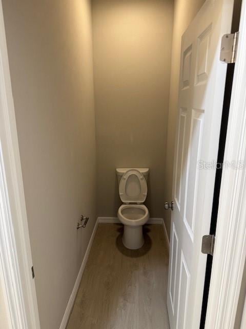 207 Baytree Dr, Rotonda West, FL 33947 - bathroom featuring wood finished floors, toilet, and baseboards