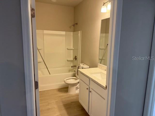 207 Baytree Dr, Rotonda West, FL 33947 - full bath with vanity, tub / shower combination, wood finished floors, and toilet