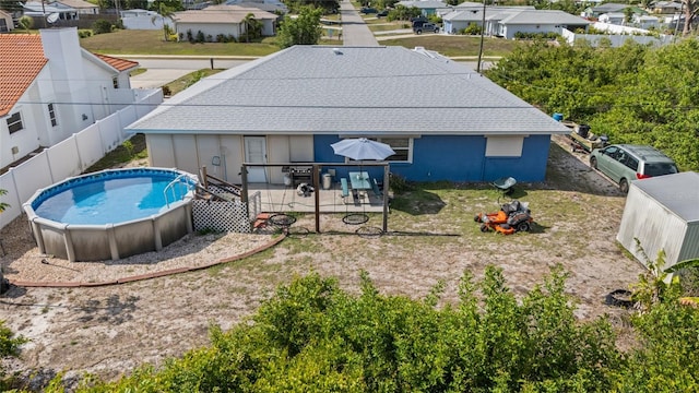 10229 Gulfstream Blvd, Englewood, FL 34224 - back of property with a fenced backyard, an outdoor pool, roof with shingles, and a residential view