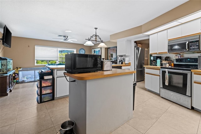 10229 Gulfstream Blvd, Englewood, FL 34224 - kitchen featuring appliances with stainless steel finishes, white cabinetry, a kitchen island, a ceiling fan, and wooden counters