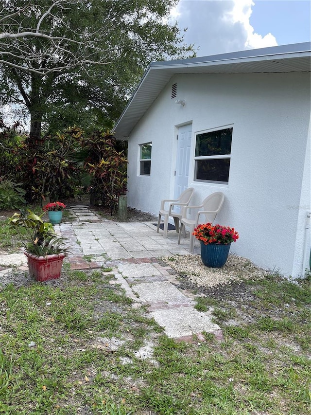 5727 Beechwood St, Punta Gorda, FL 33982 - rear view of property with stucco siding and a patio area