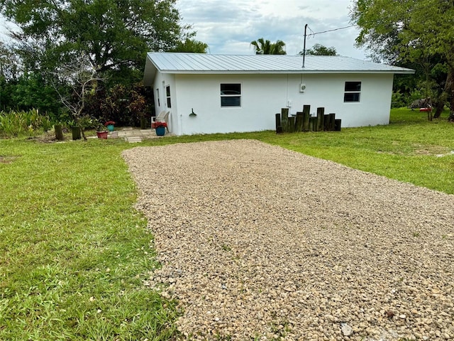 5727 Beechwood St, Punta Gorda, FL 33982 - view of front of home featuring stucco siding, a front lawn, and metal roof