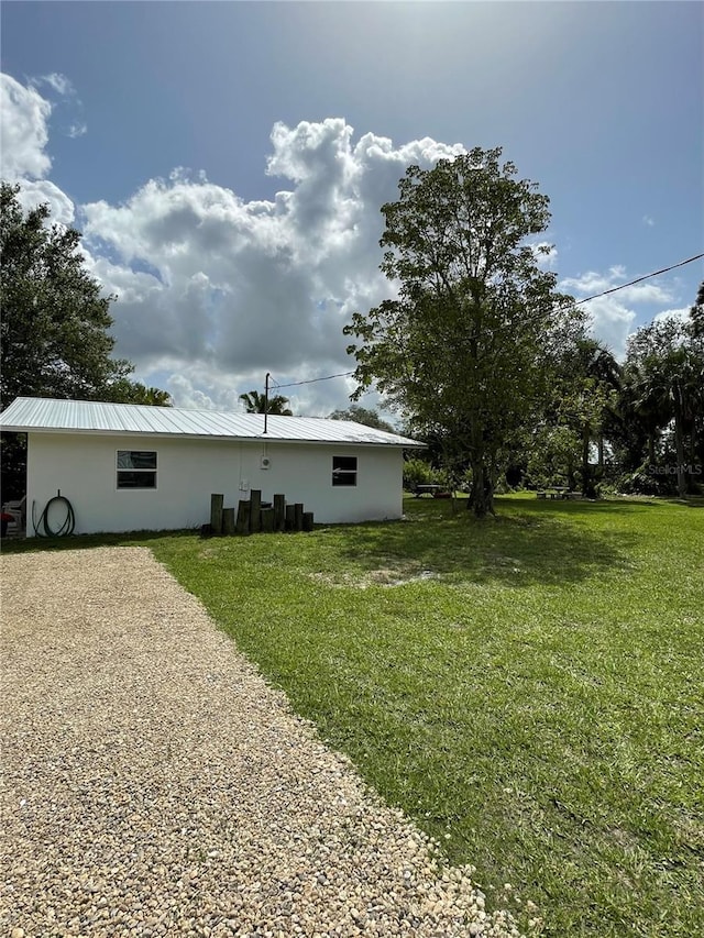 5727 Beechwood St, Punta Gorda, FL 33982 - view of home's exterior featuring a yard, stucco siding, and metal roof