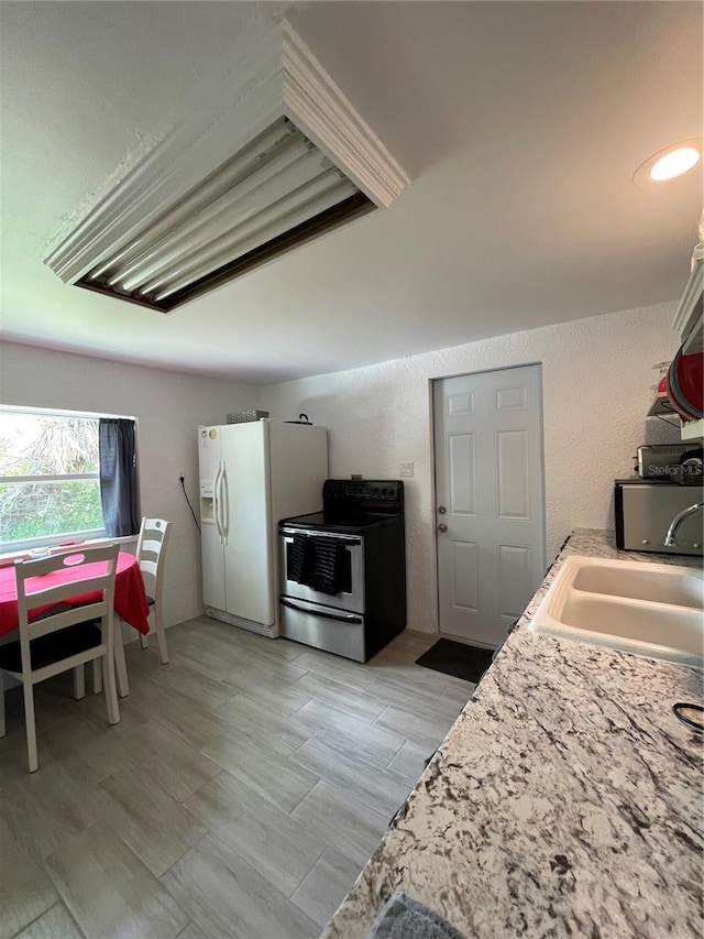 5727 Beechwood St, Punta Gorda, FL 33982 - kitchen with electric range, white refrigerator with ice dispenser, light countertops, a sink, and light wood-style floors