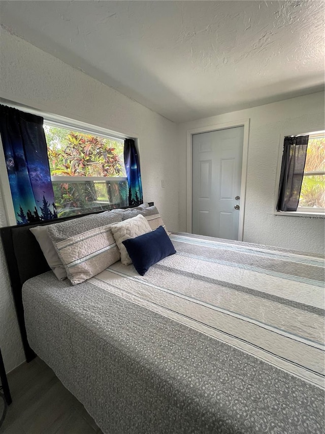 5727 Beechwood St, Punta Gorda, FL 33982 - bedroom with wood finished floors, multiple windows, a textured wall, and a textured ceiling