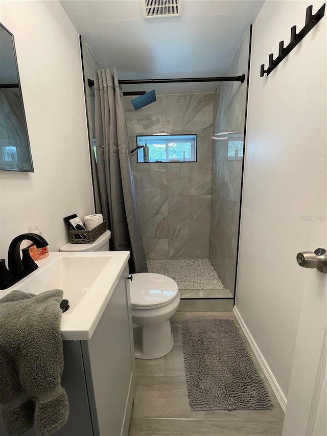 5727 Beechwood St, Punta Gorda, FL 33982 - bathroom with vanity, tiled shower, toilet, and wood finished floors