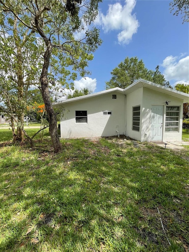 5727 Beechwood St, Punta Gorda, FL 33982 - view of home's exterior featuring stucco siding and a lawn