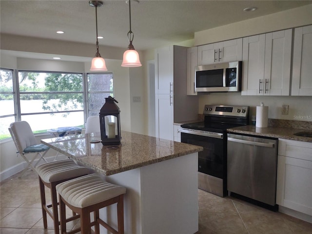 9986 SW Riverview Cir, Arcadia, FL 34269 - kitchen featuring appliances with stainless steel finishes, a center island, light tile patterned floors, white cabinetry, and recessed lighting