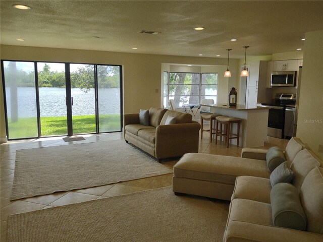 9986 SW Riverview Cir, Arcadia, FL 34269 - living area with light tile patterned floors, plenty of natural light, a water view, and recessed lighting