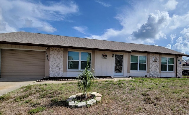 13366 Ballon Ave, Port Charlotte, FL 33981 - ranch-style home featuring a garage, concrete driveway, a front yard, stone siding, and a shingled roof