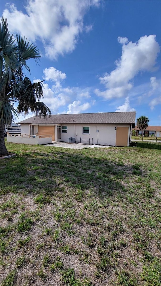 13366 Ballon Ave, Port Charlotte, FL 33981 - back of house with a patio area, a lawn, stucco siding, and central AC
