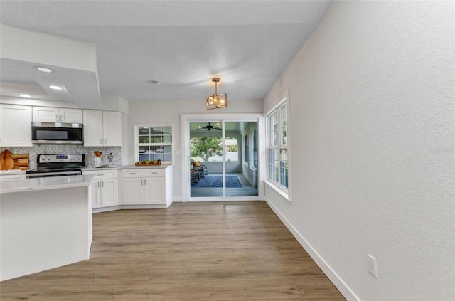 229 Waterside St, Port Charlotte, FL 33954 - kitchen featuring stainless steel appliances, white cabinets, backsplash, light wood-type flooring, and recessed lighting