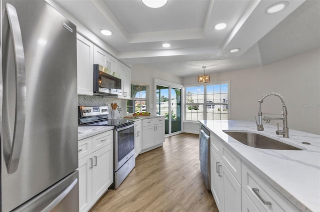 229 Waterside St, Port Charlotte, FL 33954 - kitchen featuring stainless steel appliances, a raised ceiling, white cabinetry, light wood-style flooring, and recessed lighting