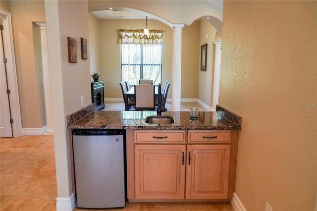 6057 Calusa Ridge Trl, Bokeelia, FL 33922 - kitchen with arched walkways, dark stone countertops, a sink, and a peninsula