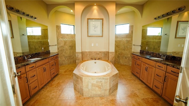 6057 Calusa Ridge Trl, Bokeelia, FL 33922 - bathroom with a bath, walk in shower, two vanities, tile walls, and tile patterned flooring