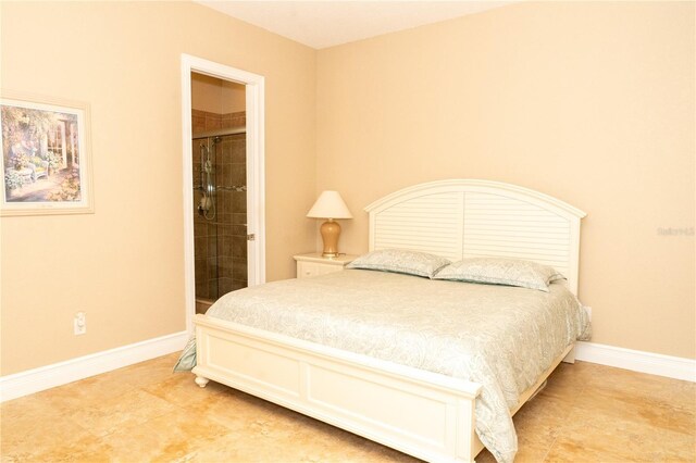 6057 Calusa Ridge Trl, Bokeelia, FL 33922 - bedroom featuring baseboards, ensuite bathroom, and light tile patterned floors