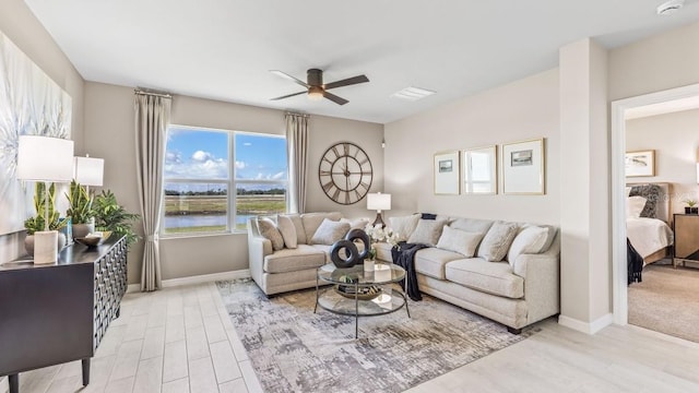9710 Sand Dune Ln, Punta Gorda, FL 33950 - living room with a ceiling fan, a water view, light wood-style flooring, and baseboards
