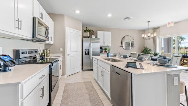 9710 Sand Dune Ln, Punta Gorda, FL 33950 - kitchen featuring appliances with stainless steel finishes, a sink, a chandelier, a center island with sink, and light countertops